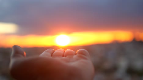 hand reaching for the sunset