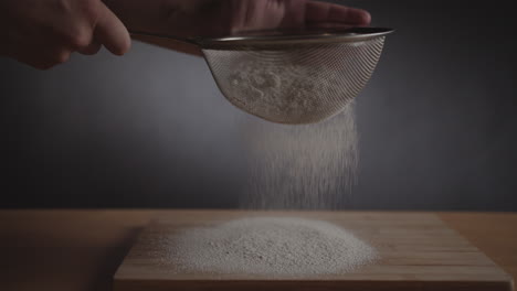 product studio shot of strainer with flour on gray background