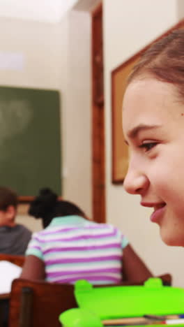 alumnos susurrando secretos durante la clase