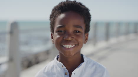 portrait happy african american boy smiling cheerful enjoying warm summer vacation on seaside beach real people series close up
