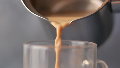 pouring coffee/tea into a glass cup