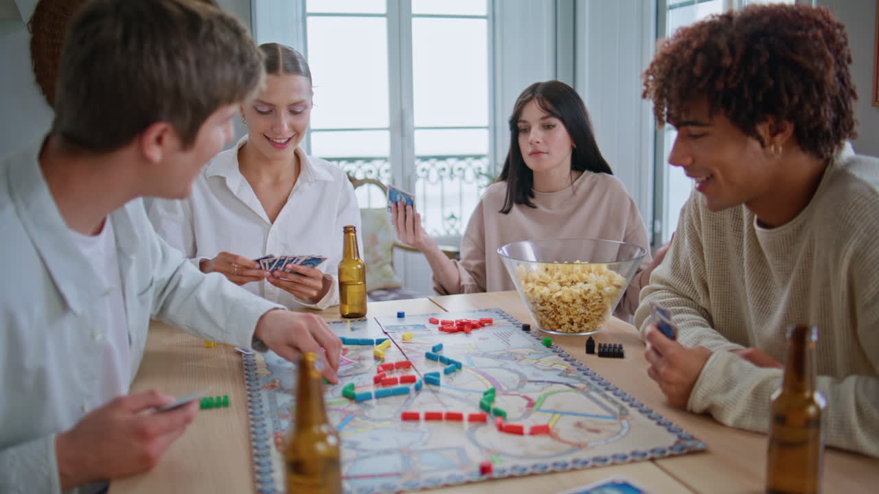 Diverse men women playing table game at home closeup. Friends enjoying playtime