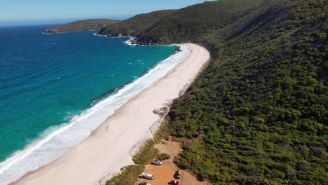 4K-Drone-video-flying-back-revealing-the-white-sand-beach-and-blue-ocean-waves