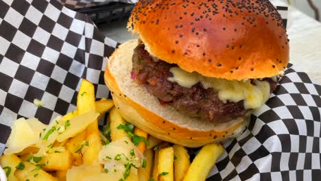 juicy cheeseburger with cheddar cheese, french fries and ketchup, fast food restaurant, 4k zoom in shot