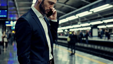 businessman talking on phone at subway station