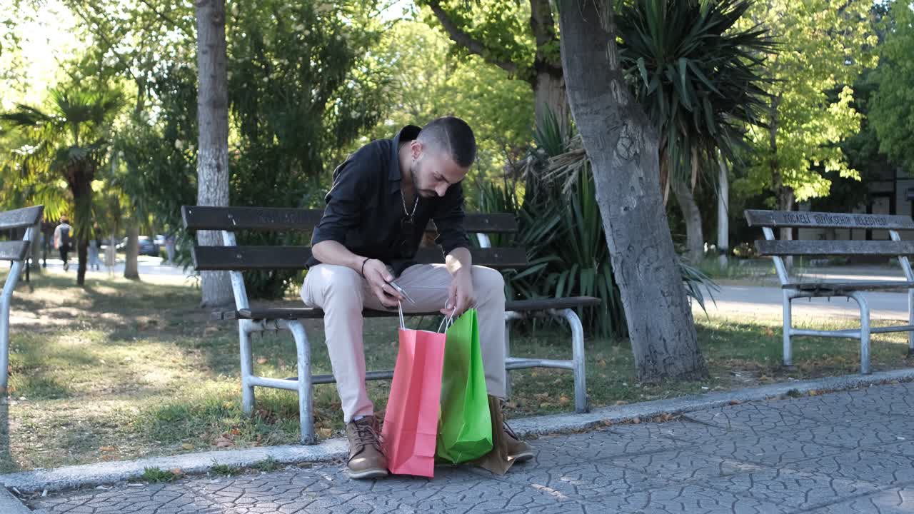 Uomo che guarda i sacchetti dello shopping