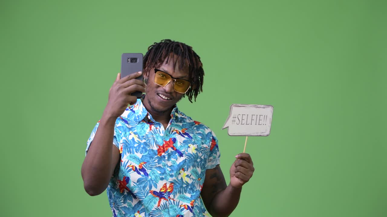 젊은 잘생긴 아프리카 관광객이 셀피를 찍고 있습니다.