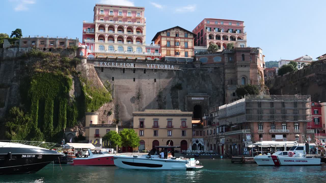 소렌토의 경치 좋은 절벽 건물 근처에 정박한 요트