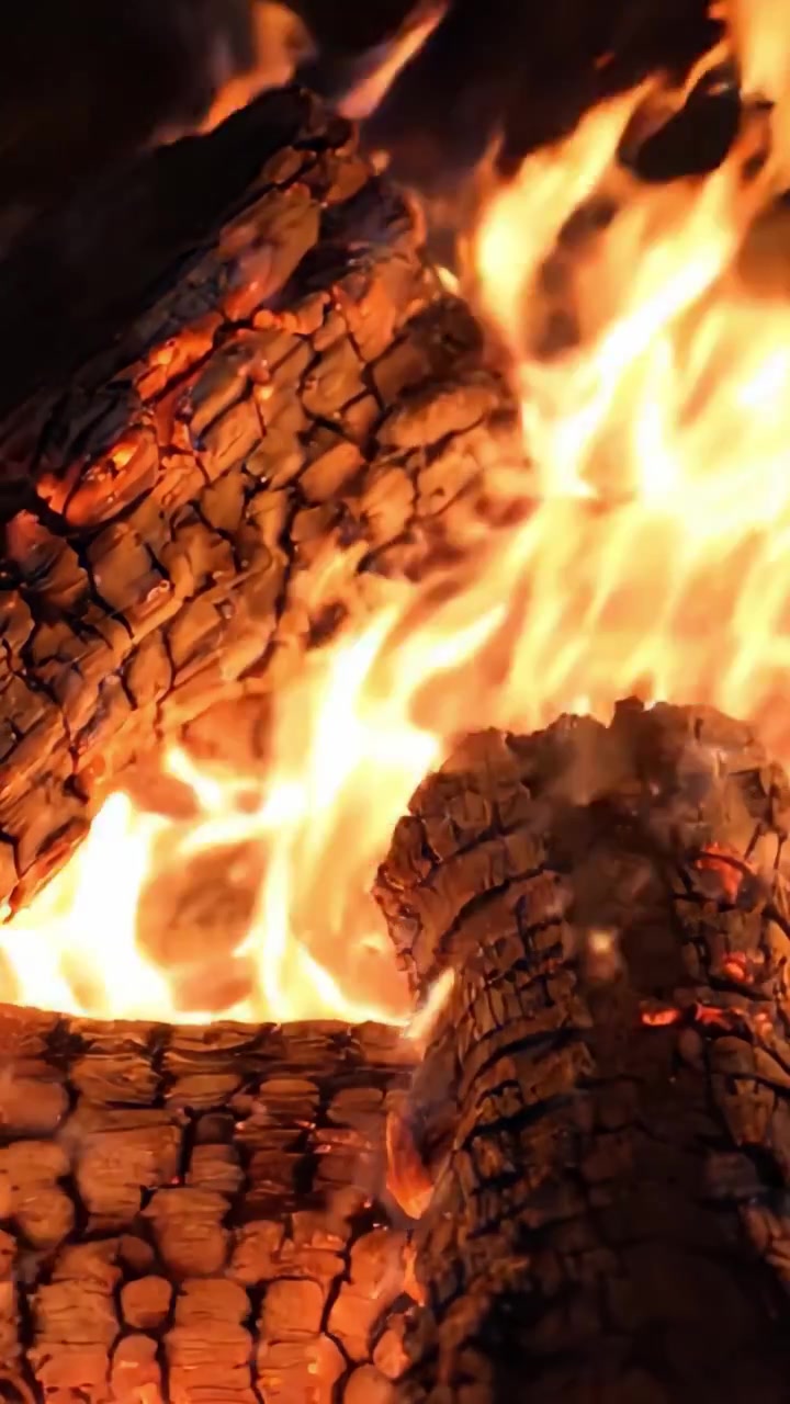 L'Affascinante Danza delle Fiamme: Una Vista Ravvicinata di Ceppi che Bruciano Irradiando Calore e Luce, Creando un'Atmosfera Invitante Perfetta per gli Incontri