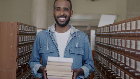 man holding books in a library