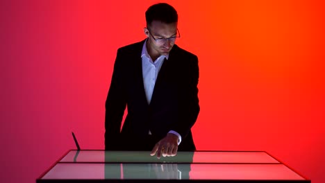the businessman working with a touchscreen in the red room