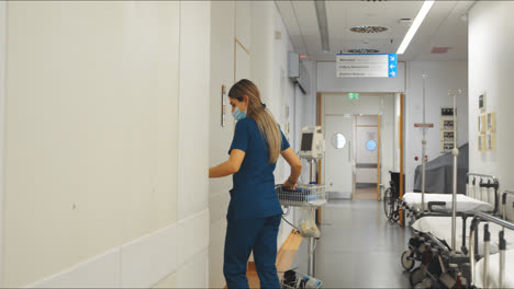 nurse entering patient room in private clinic carrying equipment for routine check up