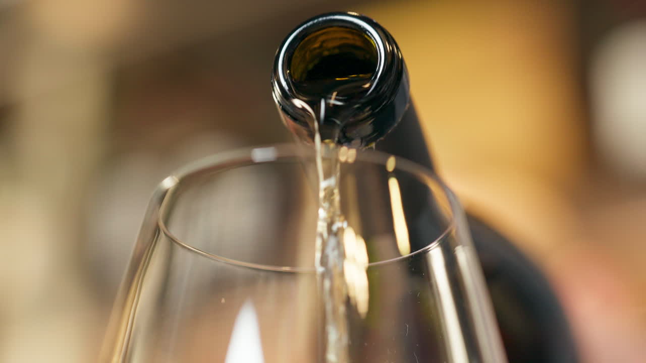 Bottle of Champagne being poured into a glass.-closeup shot