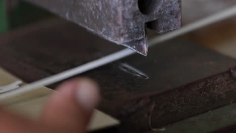 automated machine cutter cutting elastic strings for making face masks ear loops in a sew factory - covid-19 pandemic - closeup shot