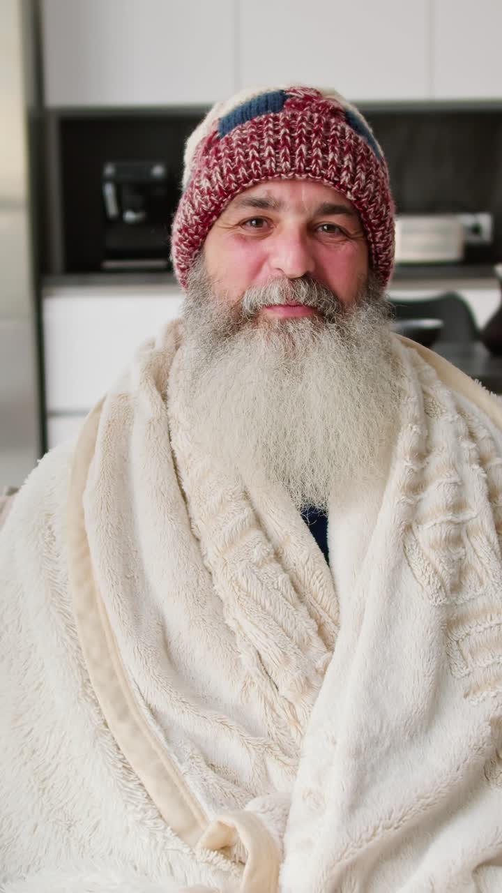 Older man wrapped in a blanket