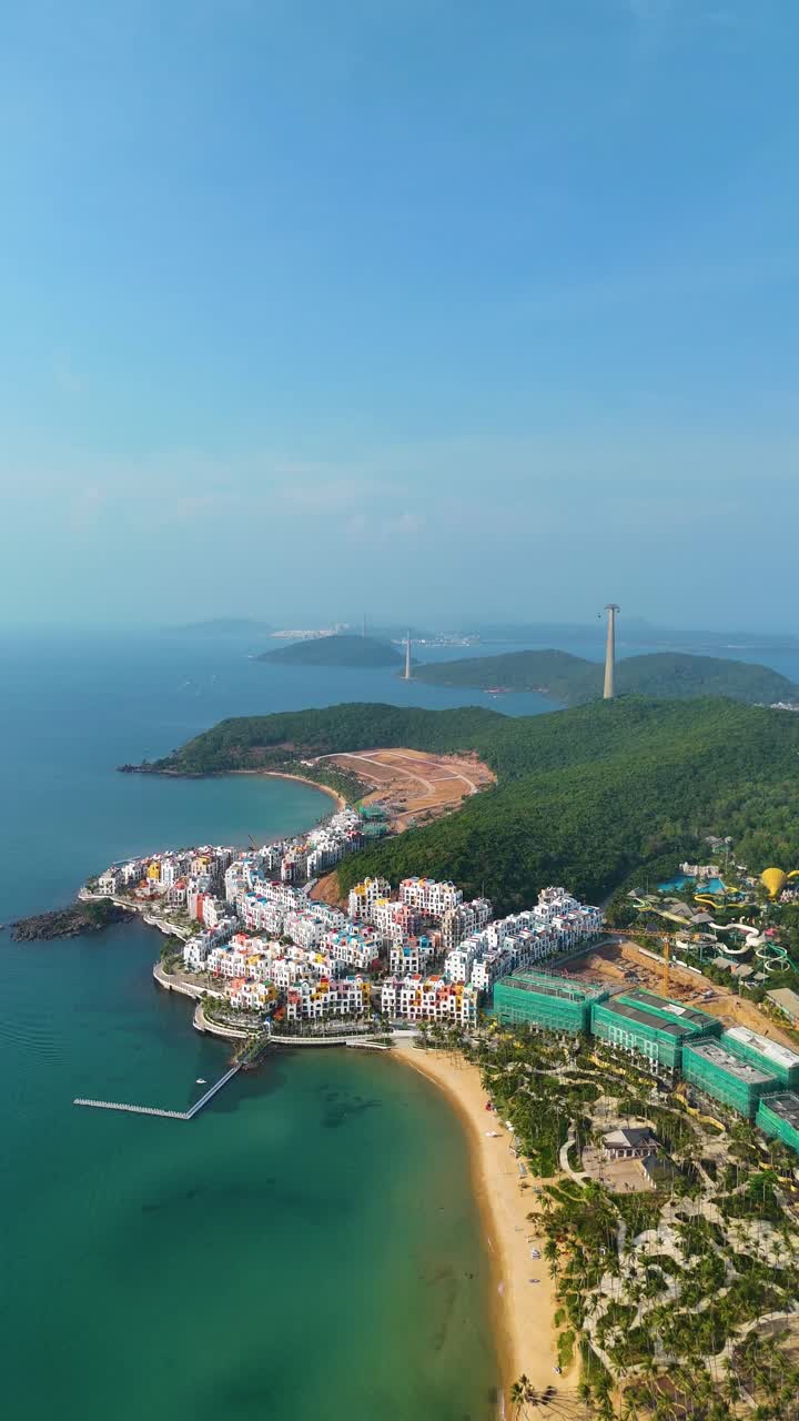 Vertical aerial view of the VinHomes construction site on Phu Quoc Island, Vietnam, showcasing the ongoing development of a luxury resort designed with Santorini-style architecture.