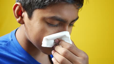 sick boy with flu blow nose with napkin