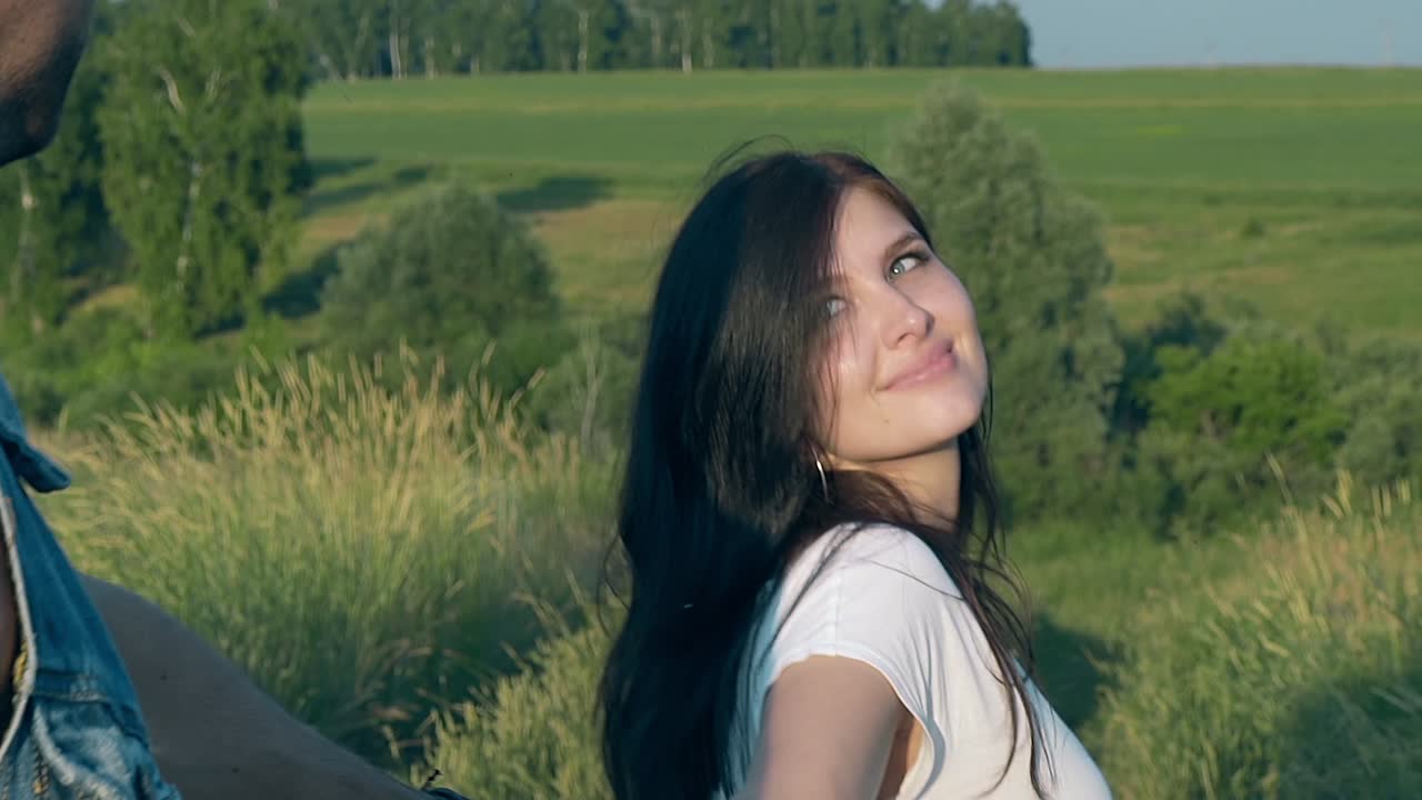 갈색 여자는 남자와 함께  ⁇ 는 예쁜 머리를 돌리고 미소 짓습니다.