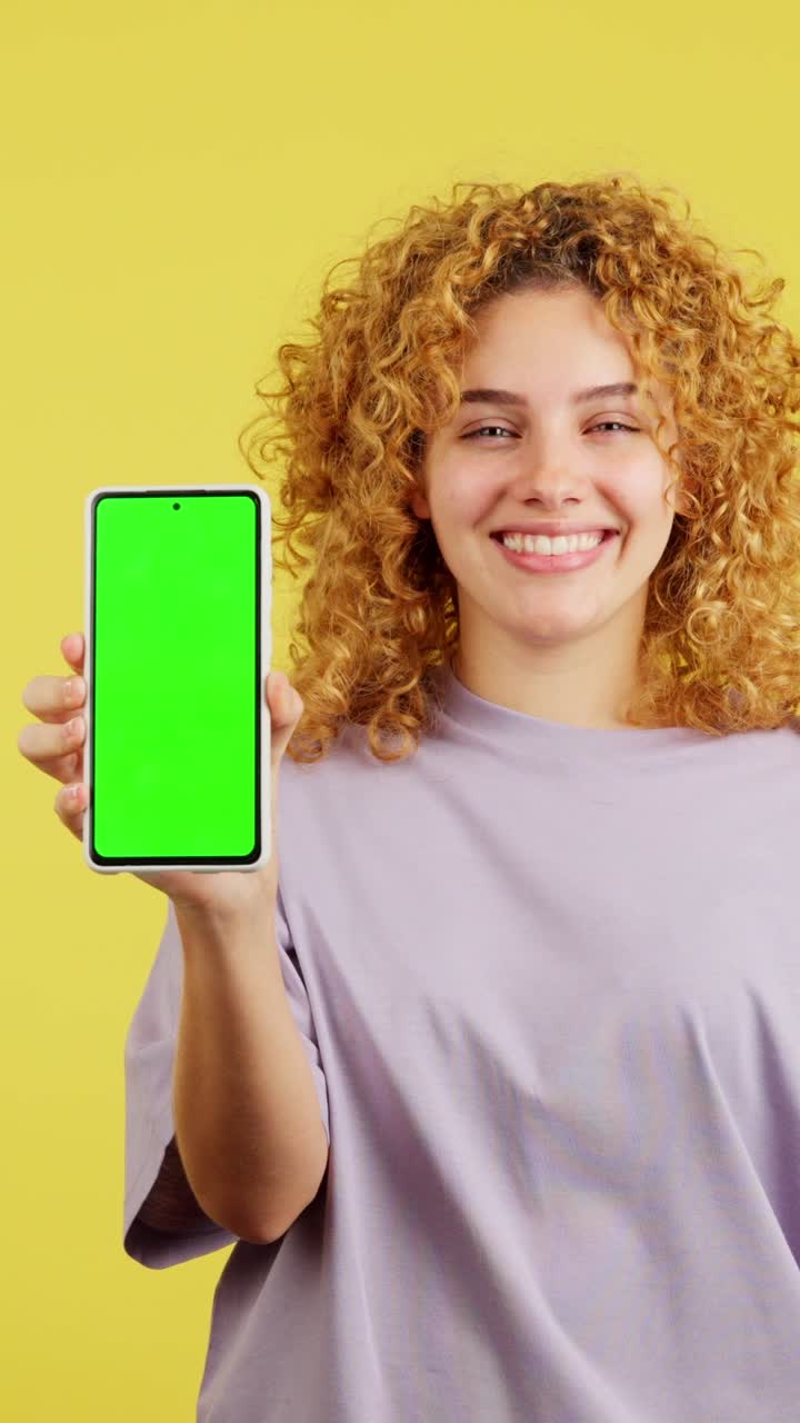 Smiling Young Woman Holding Smartphone with Green Screen