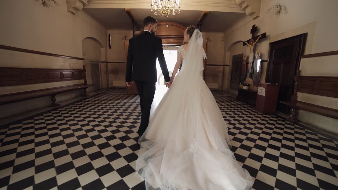 Recién casados. Novios caucásicos caminando juntos en una iglesia antigua. Boda.