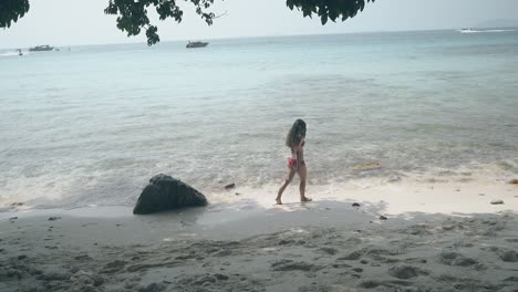 lady-with-loose-hair-walks-in-surf-line-on-ocean-coast