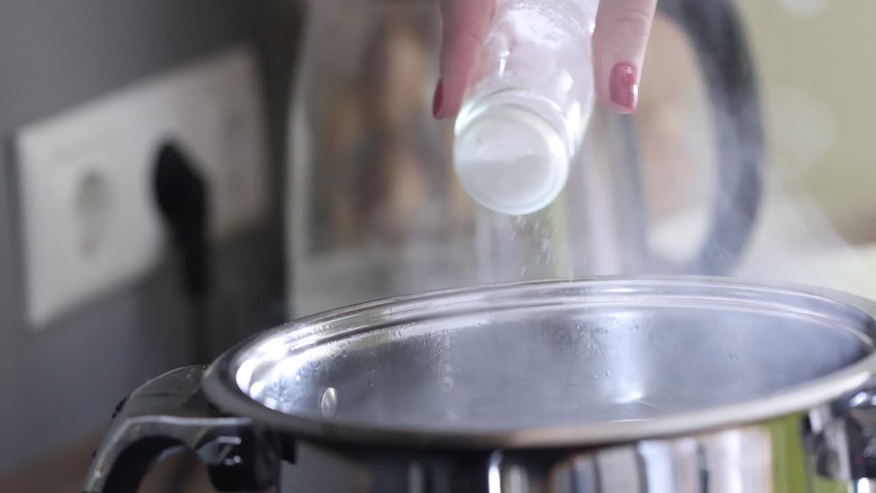 Adding Salt to Boiling Water in a Kitchen Pot