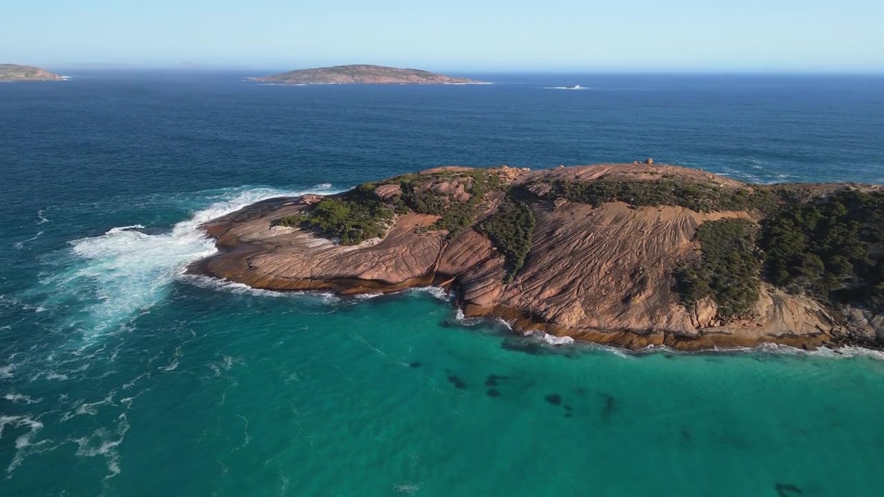 Drone cinematografico a mezzogiorno che esegue una panoramica verso l'alto per rivelare lo sfondo dell'oceano all'orizzonte.