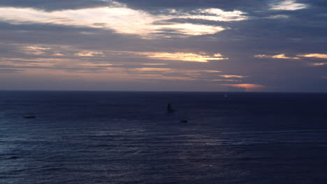 silueta de barcos en el océano al atardecer, nubes coloridas en la línea del horizonte, hawaii, tiro ancho