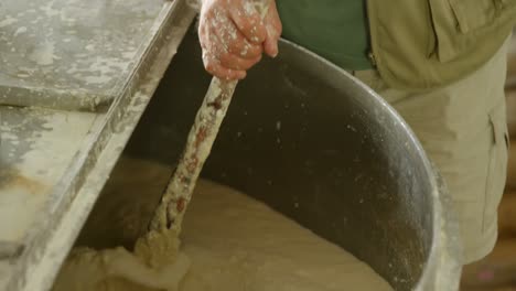 male worker stirring gin in distillery 4k