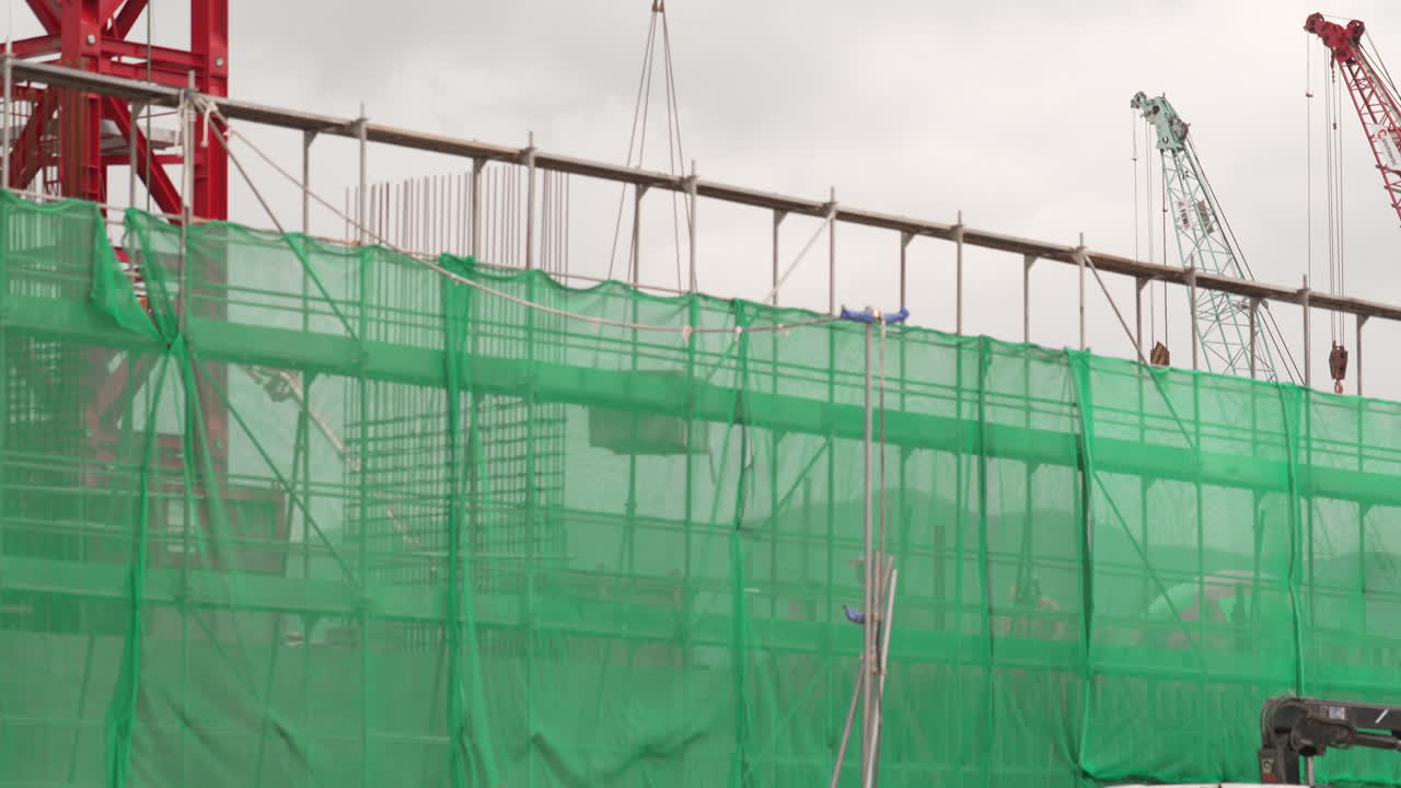 Crate Box Being Moved By Tower Crane At The Construction Site. low angle, wide