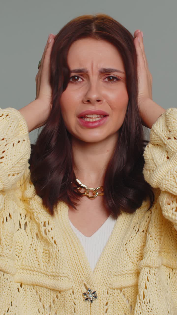 Ragazza irritata e irritata che copre le orecchie, che fa gesti, che non evita i consigli, che ignora il rumore, le voci forti.