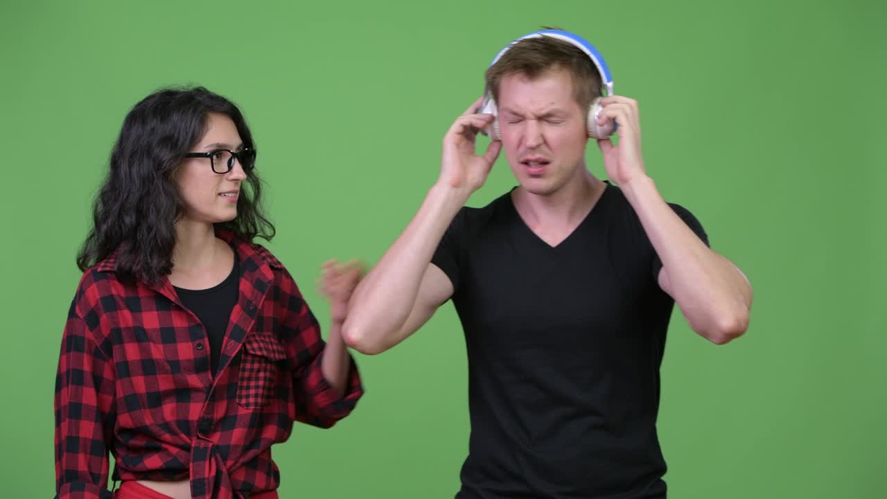 젊은 여성이 젊은 남자와 이야기하고 음악을 듣고 늦어지고 있습니다.