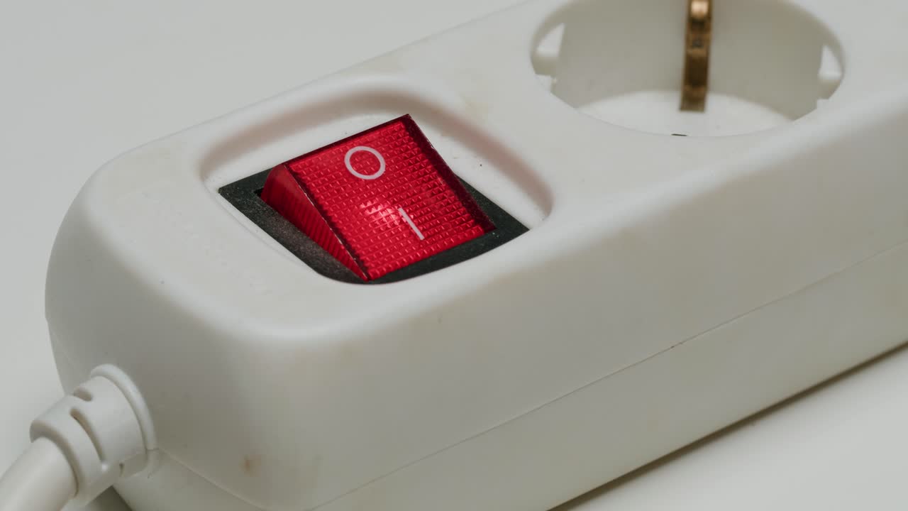 Close-up of a power strip with the on/off switch pressed on