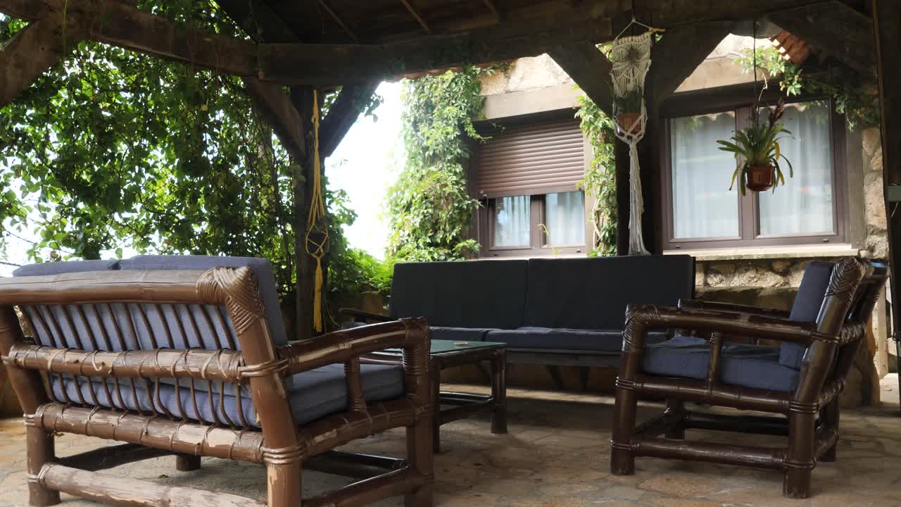 porch terrace in a rustic house with a vintage sofa, couch and dinner table