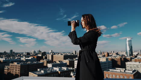 woman taking photos on rooftop cityscape