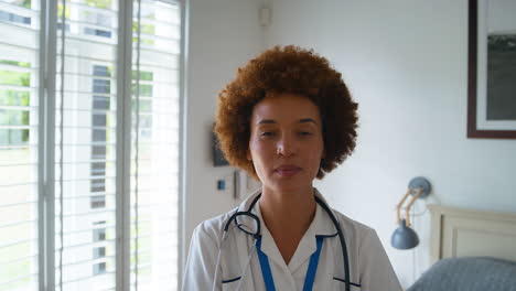 Portrait-Of-Smiling-Female-Nurse-Wearing-Uniform-With-Digital-Tablet-In-Private-Hospital-Room