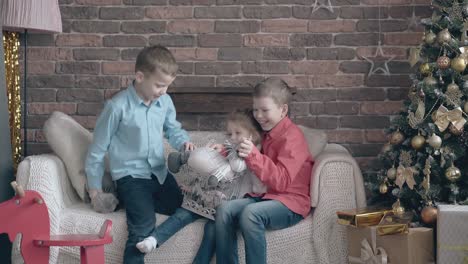 fair haired siblings try to fit toys into decorative cage