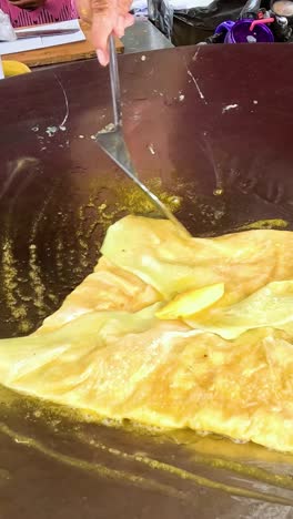 el vendedor prepara pan-fried roti en kanchanaburi