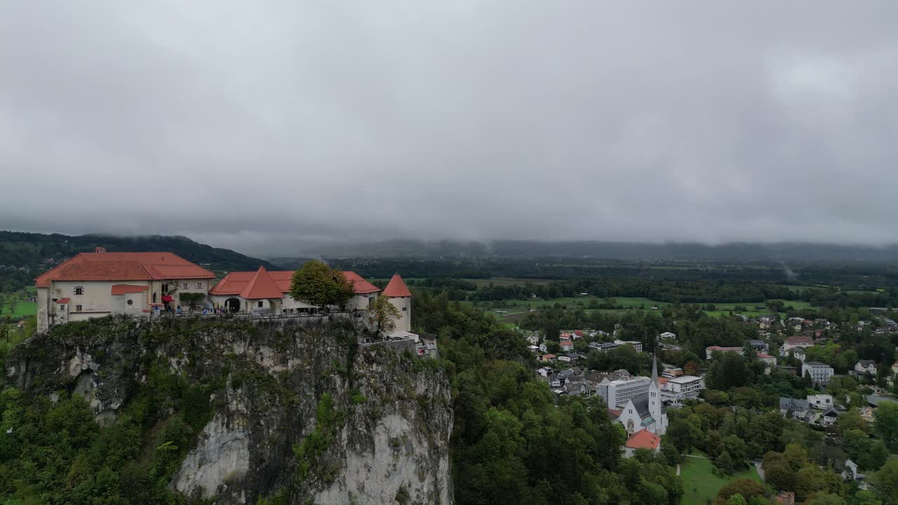 la vista aérea del dron del castillo de bled eslovenia revela un clima tormentoso en el fondo