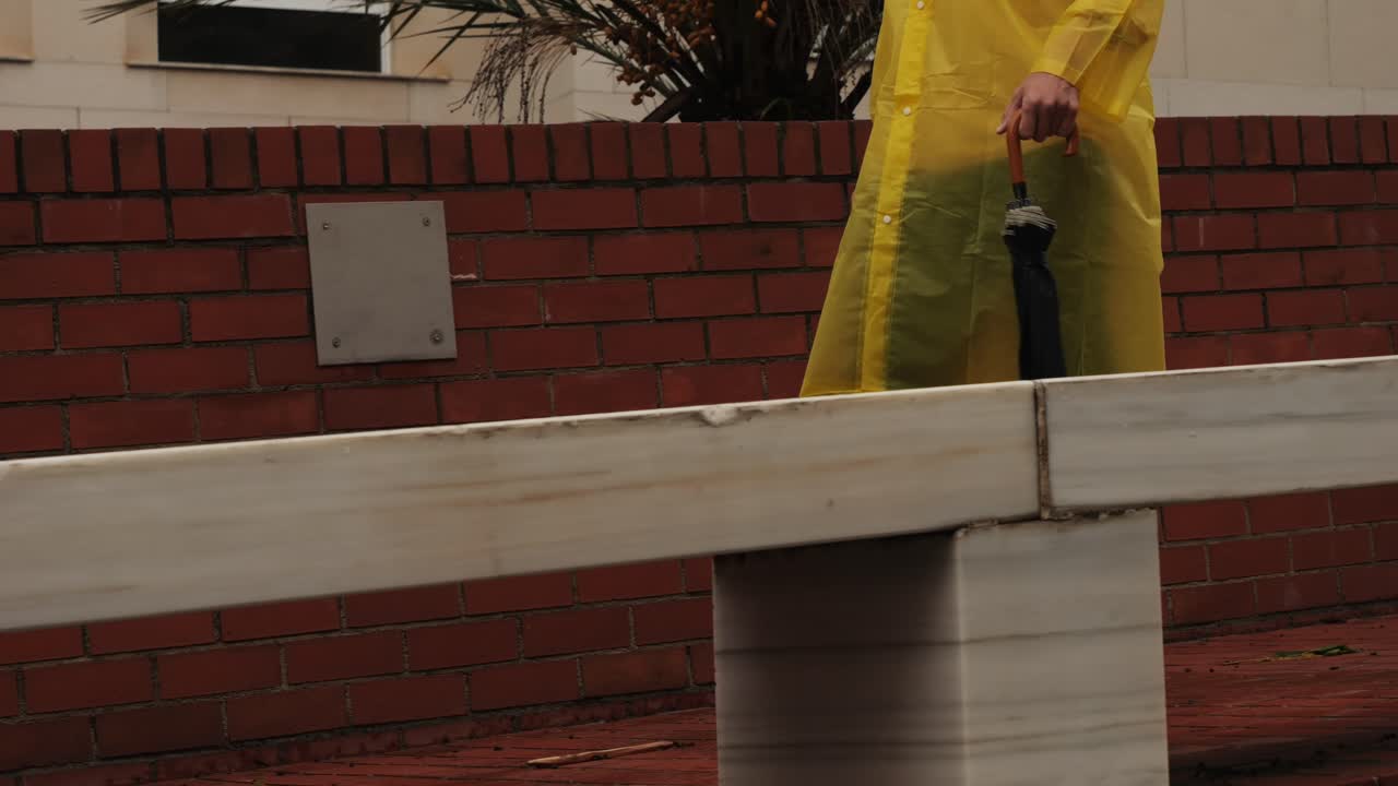 Business man tourist person with umbrella and raincoat on rainy european city street, lights reflecting, walking in Barcelona or Amsterdam during the rain