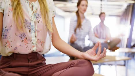 business people performing yoga on table