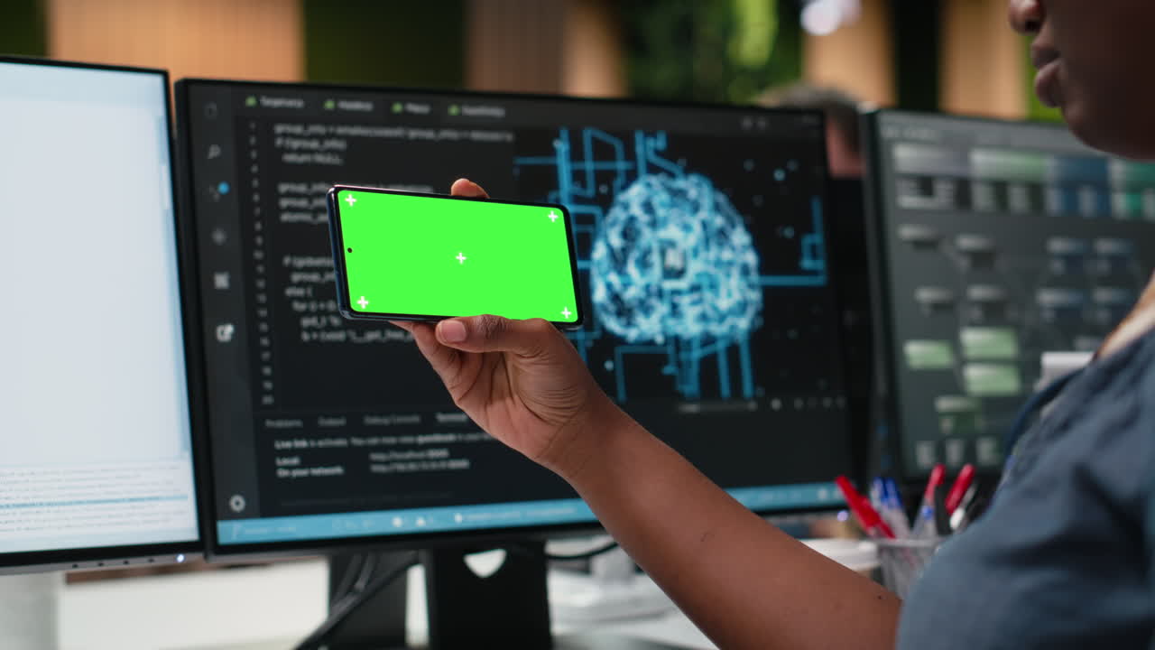 Person Holding Green Screen Smartphone in Modern Tech Office