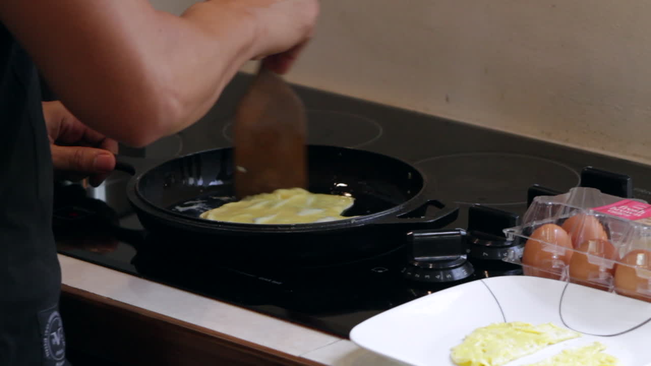 남자는 주철 프라이팬에 계란을 요리
