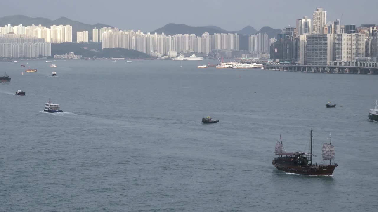 Many boats float in Hong Kong's Victoria Harbour with view of skyline