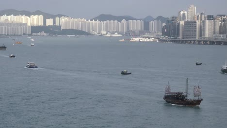 many boats float in hong kong's victoria harbour with view of skyline