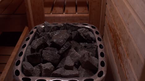 water pouring over hot coals in sauna, close up high angle shot