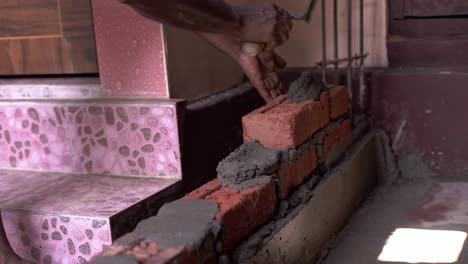 un muro de construcción con ladrillo y hormigón en el sitio de construcción carpintero negro trabajando en el sitio
