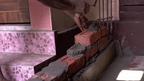 building a wall with brick and concrete in construction site black carpenter working on site