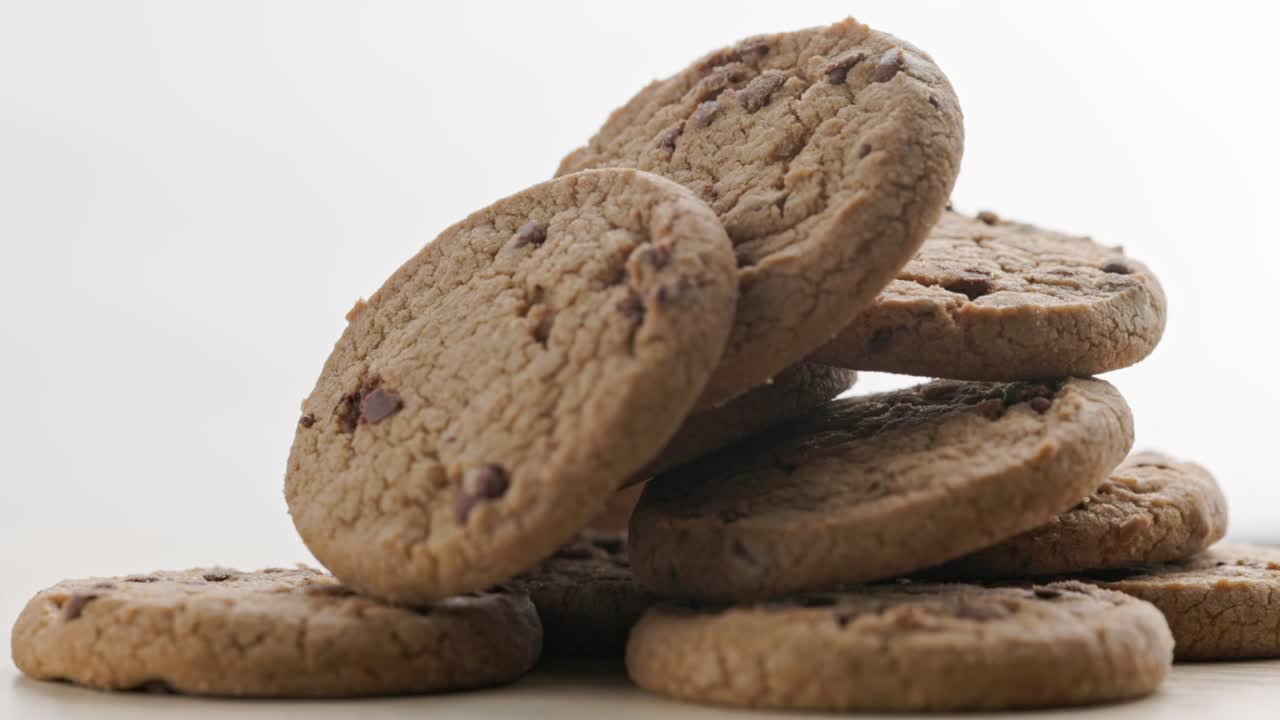 round chip cake cookies with chocolate on white surface slow rotating looped background