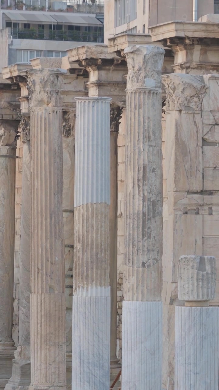 Inquadratura verticale in tilt up delle colonne di marmo e dei capitelli corinzi della Biblioteca di Adriano ad Atene, Grecia, che evidenzia la notevole architettura romana del sito